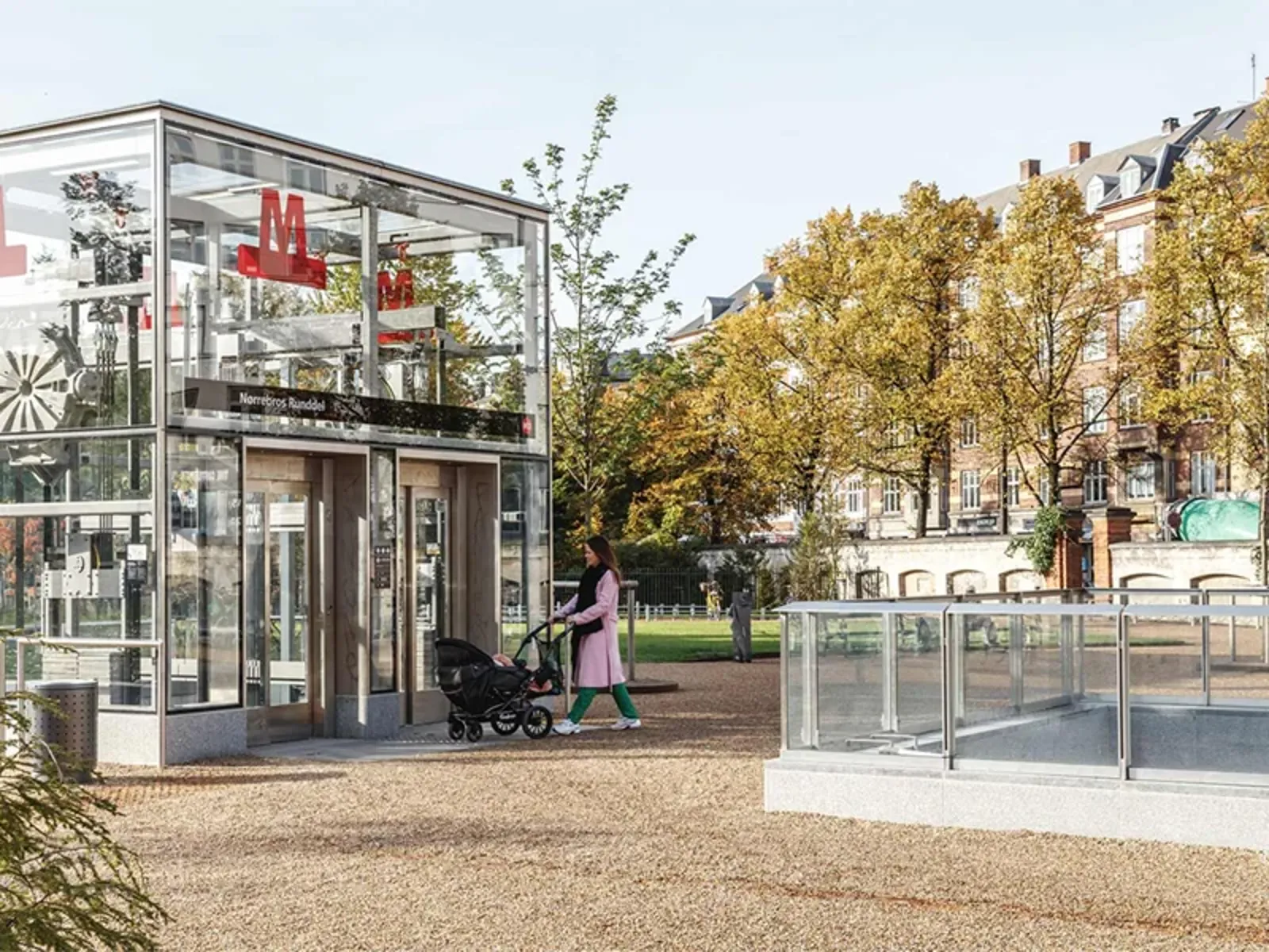 A person walking with a stroller to a lift down to a metro station