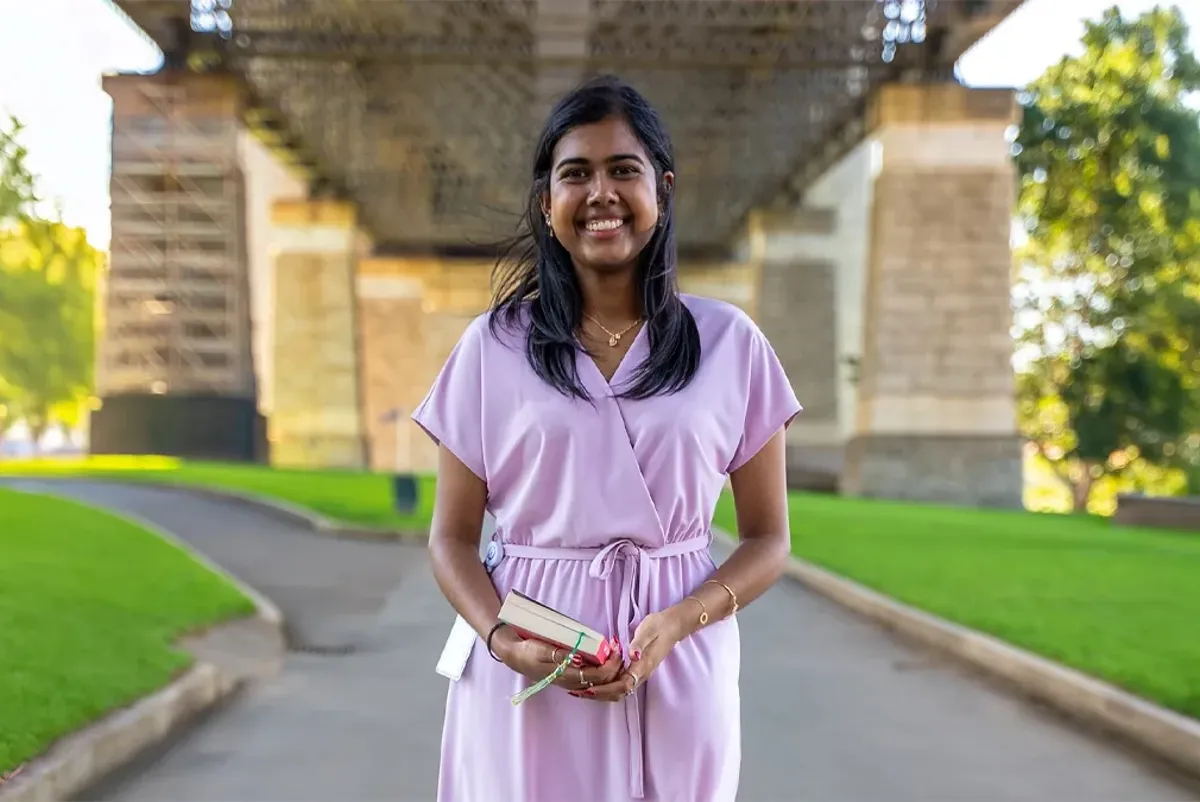 A woman standing on a path under a bridge