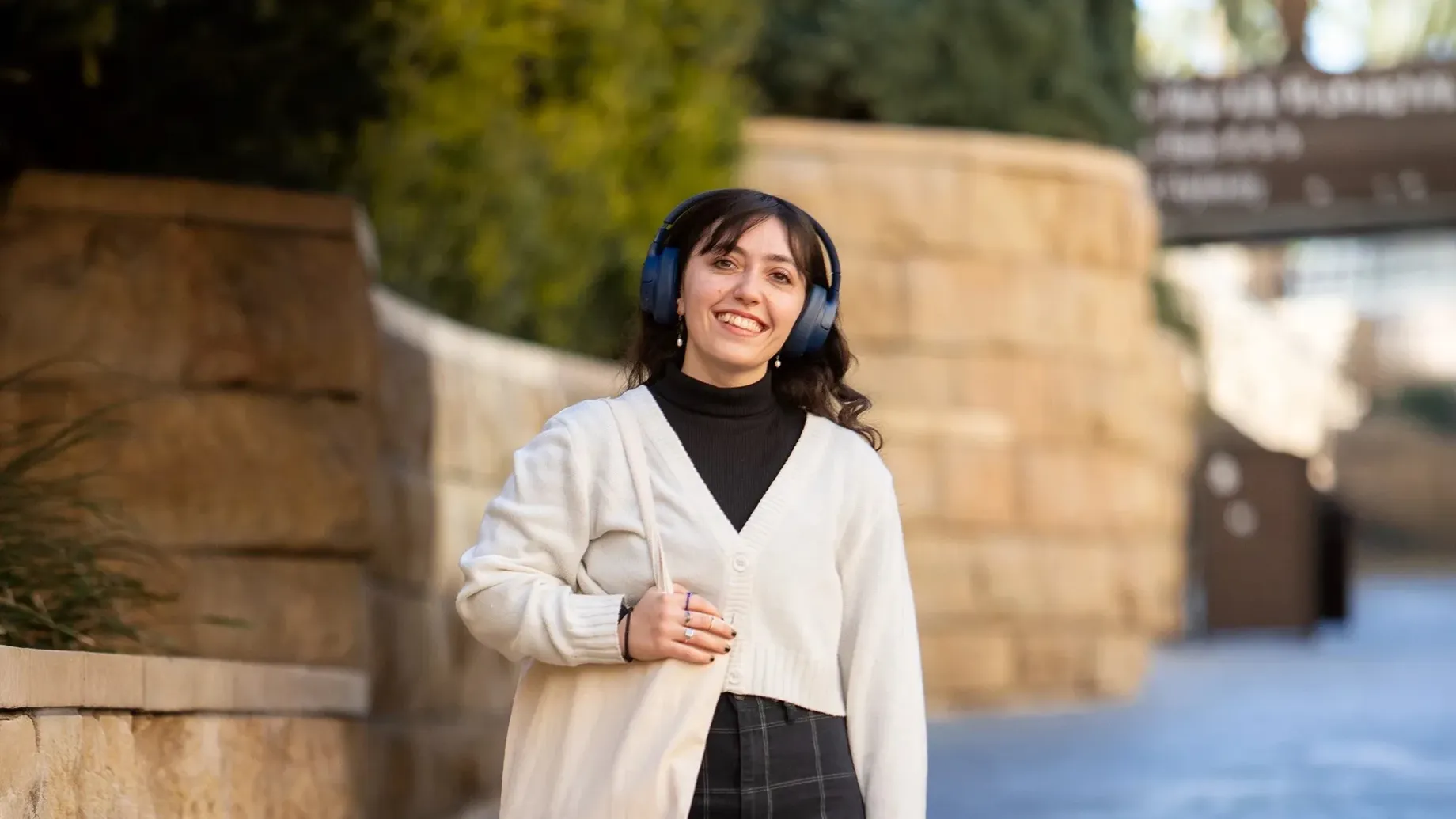 A girl smiling standing in front of a low wall