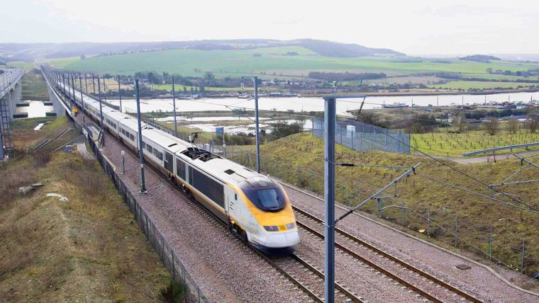 A high speed train travelling through a rural setting