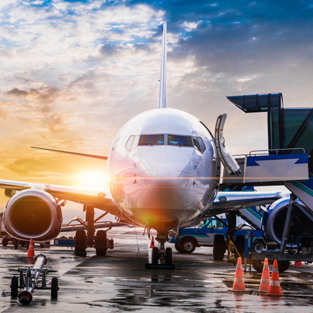 Airplane at an airport with a plane taking off in the background