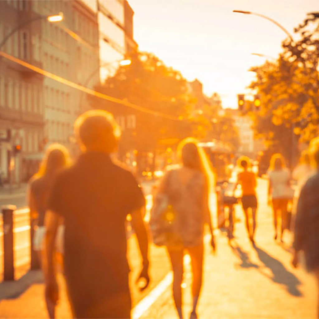 People in city bathed in sunlight