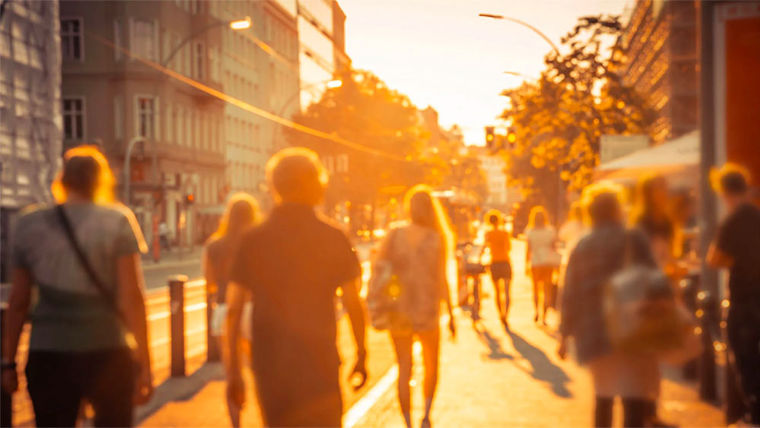 People in city bathed in sunlight