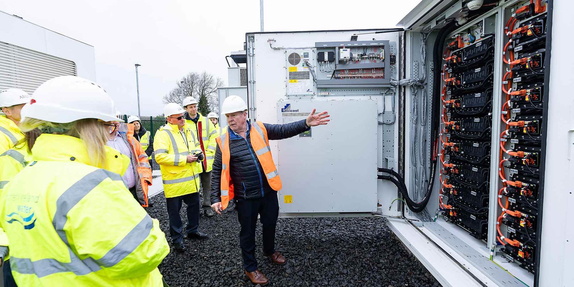 Team member showing one of the large-scale battery energy storage systems