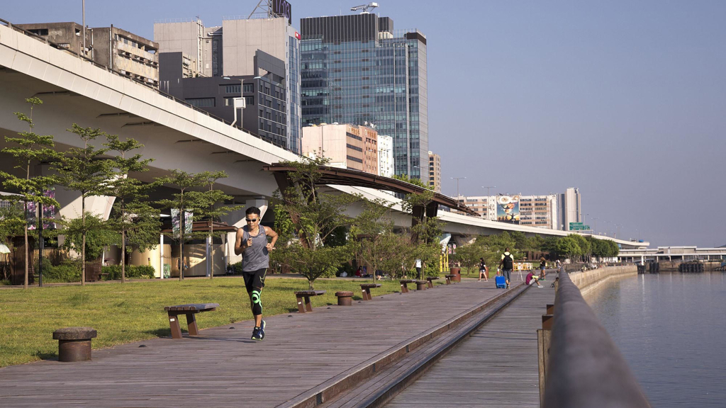 A person running along a waterfront in a city