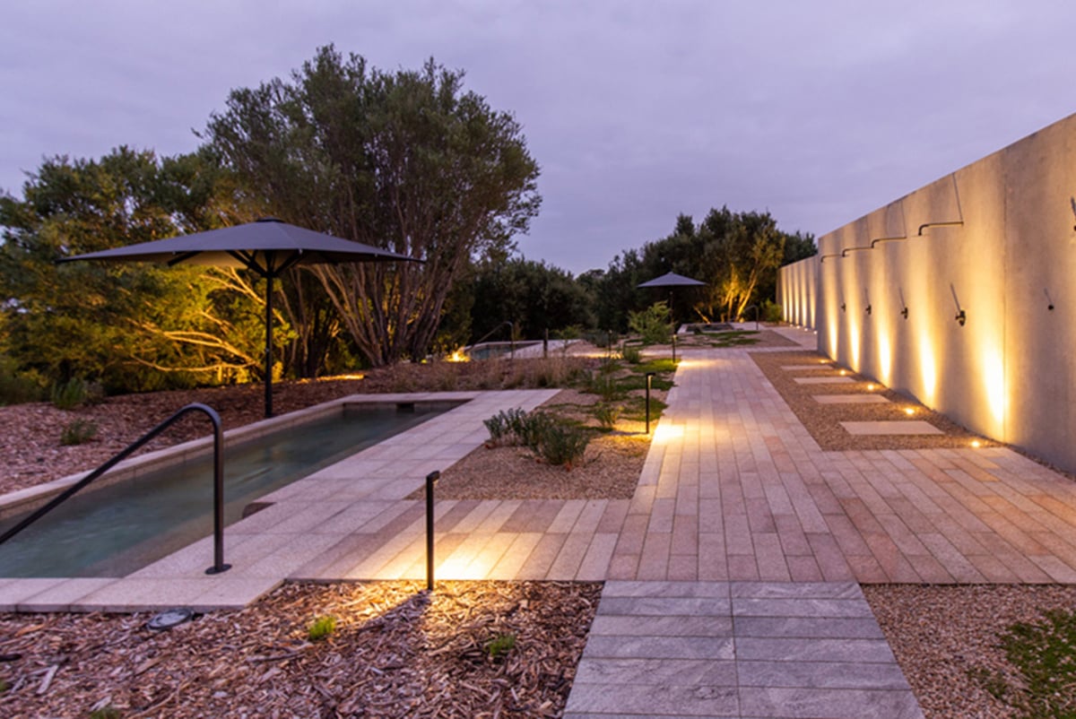 Outdoor pool, paths with wall with mood lighting at dusk