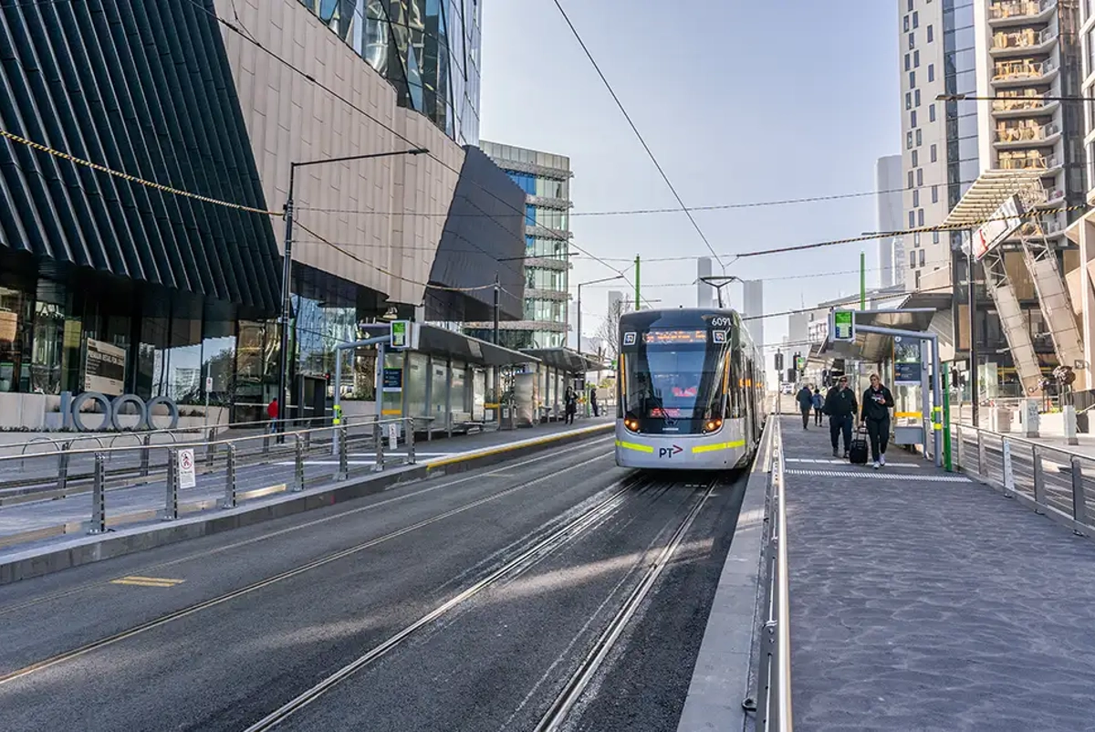 Melbourne tram at a platform with passengers waiting