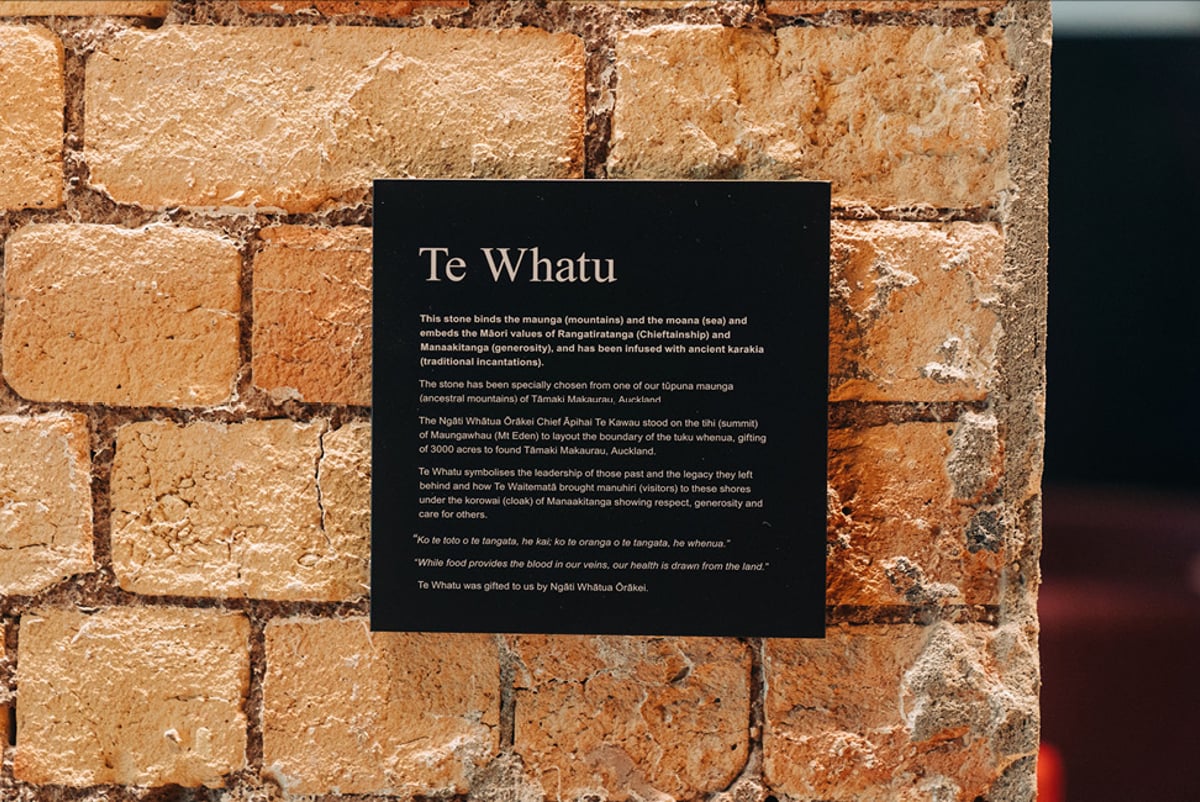 Māori signage on a plaque on a brick wall in an office. Credit: All Good Media