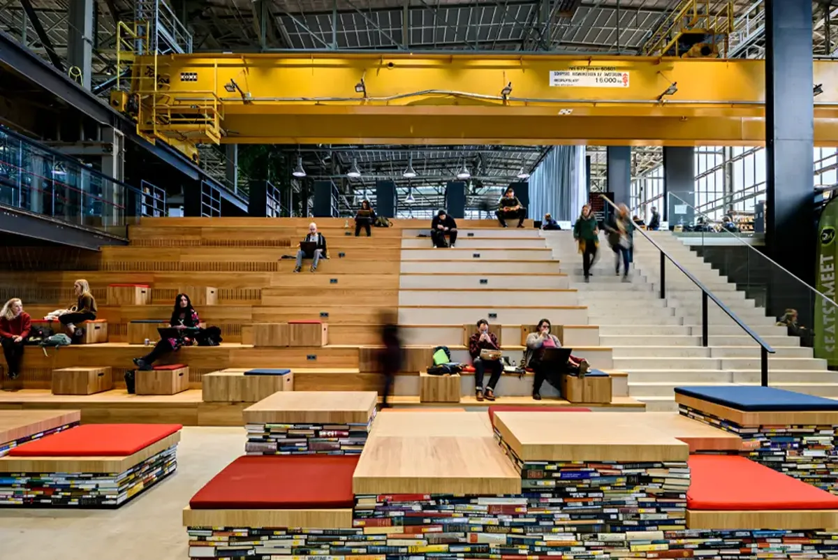 A wooden seating area inside a large industrial building