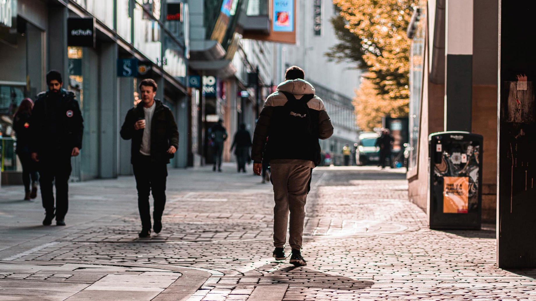 People walking down a street in Manchester