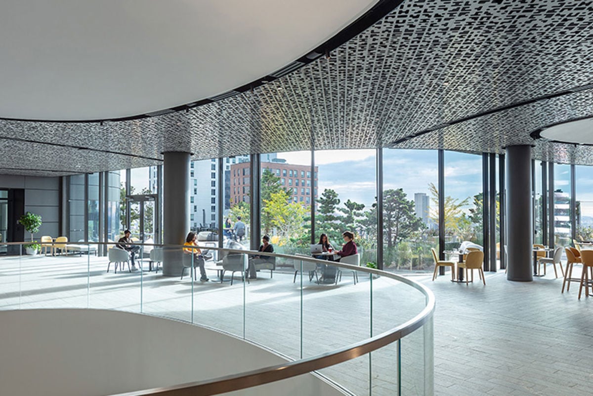 An interior gathering space with chairs, tables and lots of natural light