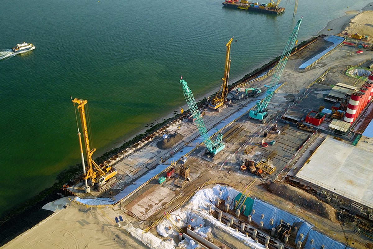 View over a construction site for an offshore marine centre in Singapore with cranes and machinery