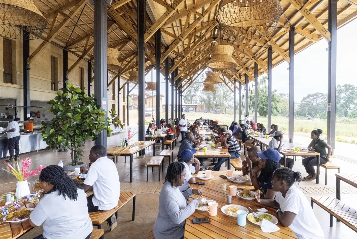 A group of people eating at the Rwanda Institute for Conservation Agriculture