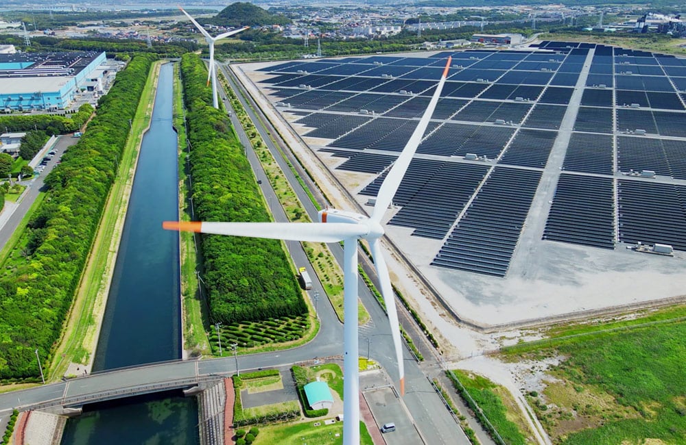 Solar panels and wind turbines alongside a canal
